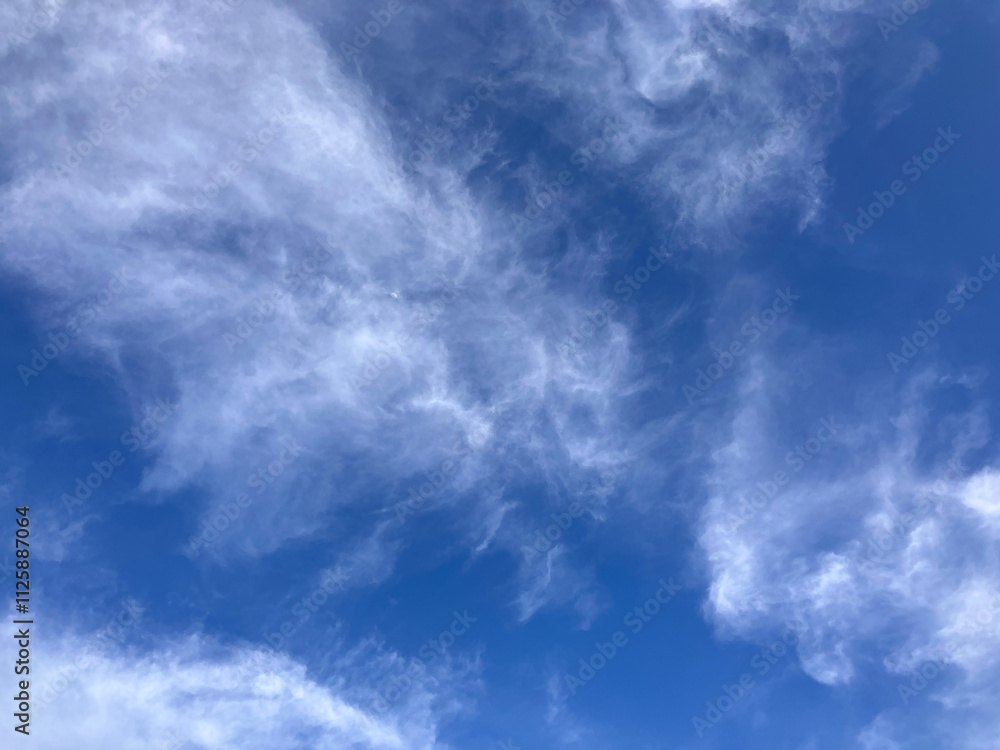 Obraz premium Dreamy Cloudscape: Soft, Feather-Like Clouds Painted Against a Radiant Blue Sky