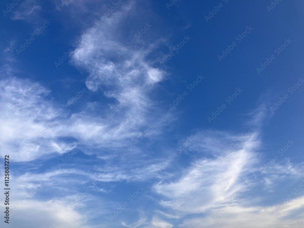 Elegant Sky Dance: Wispy Clouds Flowing Gracefully Across a Deep Blue Horizon Elegant Sky Dance: Wispy Clouds Flowing Gracefully Across a Deep Blue Horizon