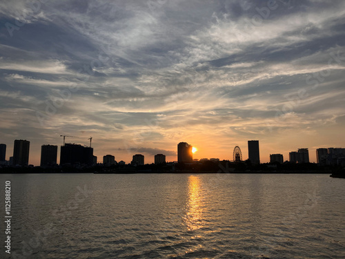 City Sunset Silhouette: Urban Skyline Reflected Over Calm Waters at Dusk