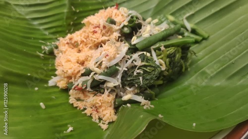 Gudangan is a traditional dish from Java, Indonesia made from a variety of green vegetables such as spinach, papaya leaves and others that are boiled, then mixed with grated coconut sauce. photo