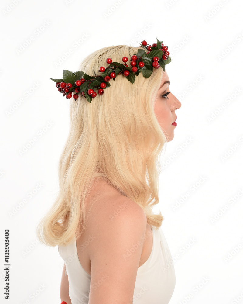 Naklejka premium close up portrait of beautiful blonde female model wearing holly and ivy Christmas fantasy wreath crown headdress. isolated silhouette, looking away in side profile on white studio background.