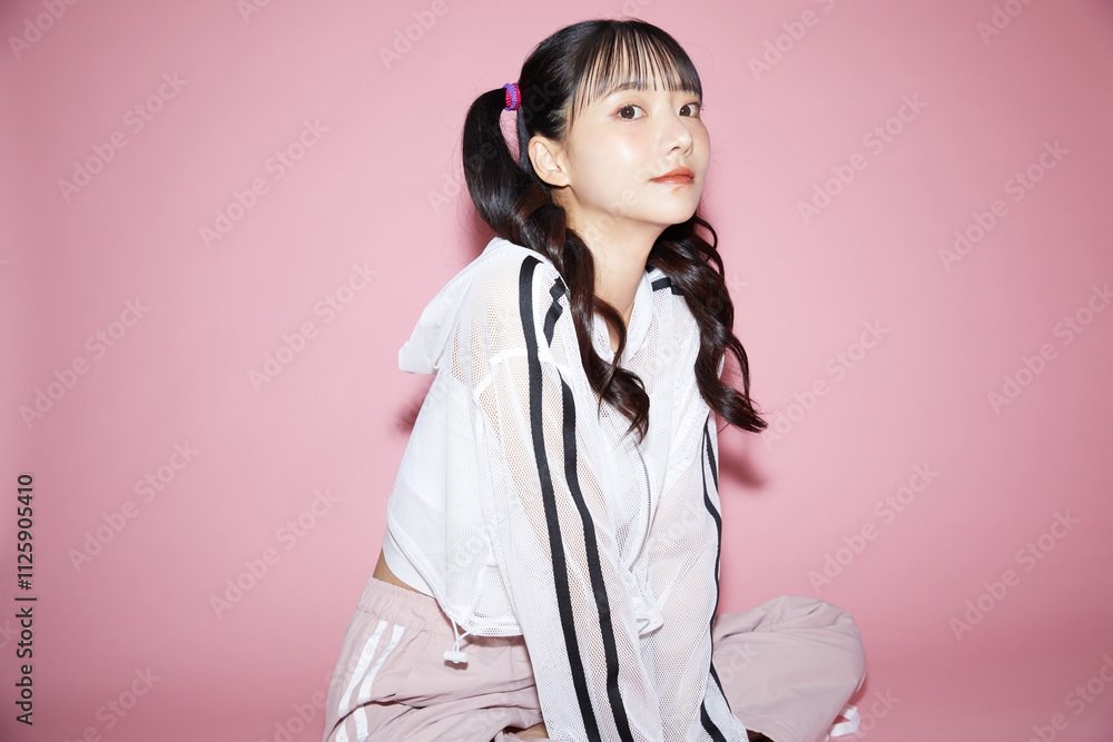 ピンク背景で撮影をしたスポーティな服装をした若い女性のキュートなポートレート ピンク背景で撮影をしたスポーティな服装をした若い女性のキュートなポートレート