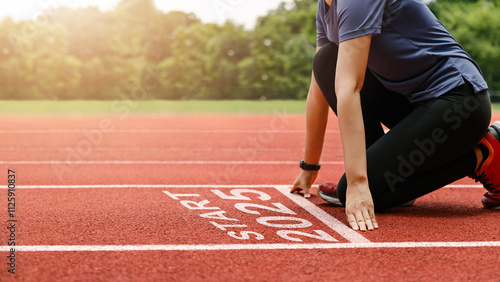 Starting to the new year 2025. woman preparing to start on an athletics track engraved with the year 2025. idea for planning, goals and New Year's resolutions.Adopting Success in 2025 for New Life.