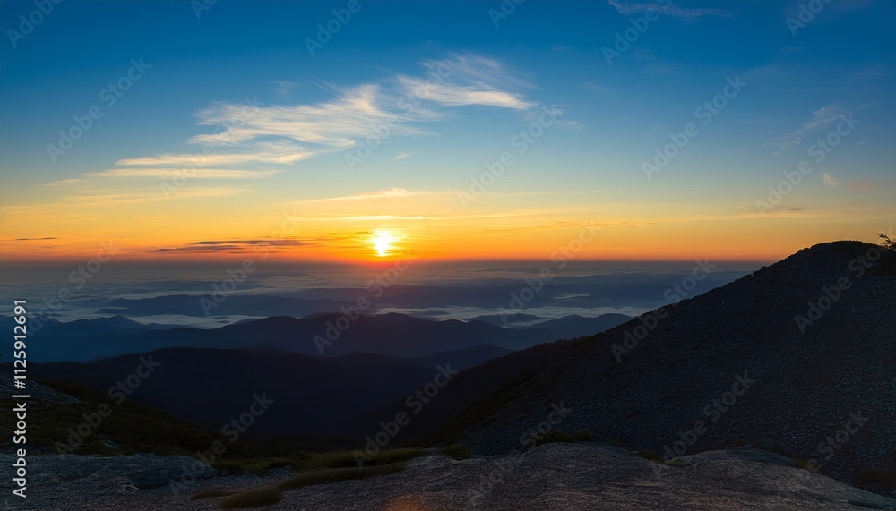 Golden sunlight paints the sky as it sets behind distant mountains, casting a warm glow over the serene landscape Golden sunlight paints the sky as it sets behind distant mountains, casting a warm glow over the serene landscape