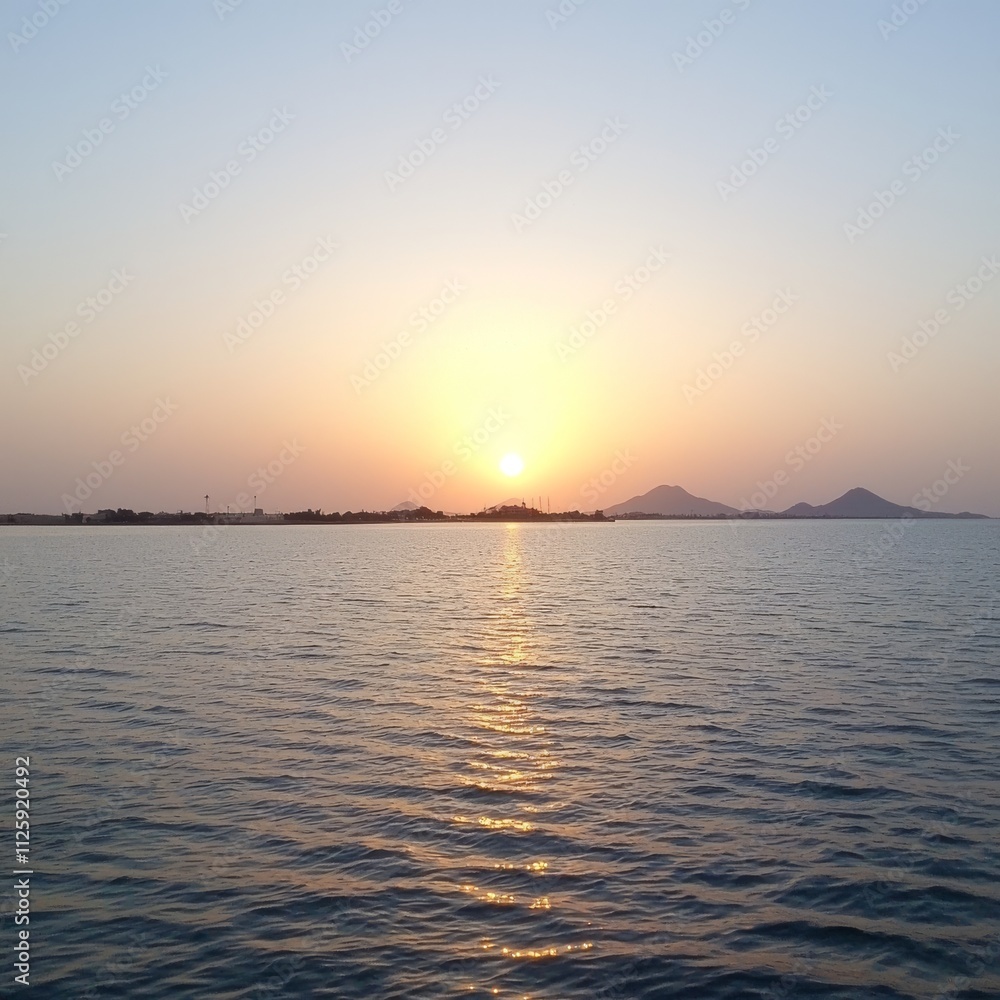 Serene Sunset Over Calm Ocean and Distant Hills Serene Sunset Over Calm Ocean and Distant Hills