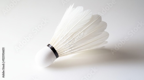 11.High-definition close-up of a single feathered badminton shuttlecock isolated on a clean white background; the shuttlecockâ€™s feathers are pristine and evenly spaced, with fine detailing on the photo