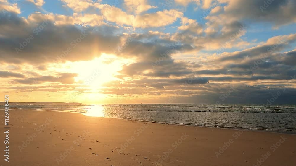 A beautiful sunrise over the beach lights up the clouds, creating a calm and tranquil coastal scene A beautiful sunrise over the beach lights up the clouds, creating a calm and tranquil coastal scene