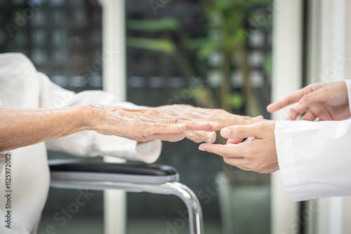 Senior stretching her arms,doctor examines the patient's hands for any tremors,signs of thyroid -related issues or diseases of  Hyperthyroidism,Stroke,Parkinson's disease,health care,medical concept photo