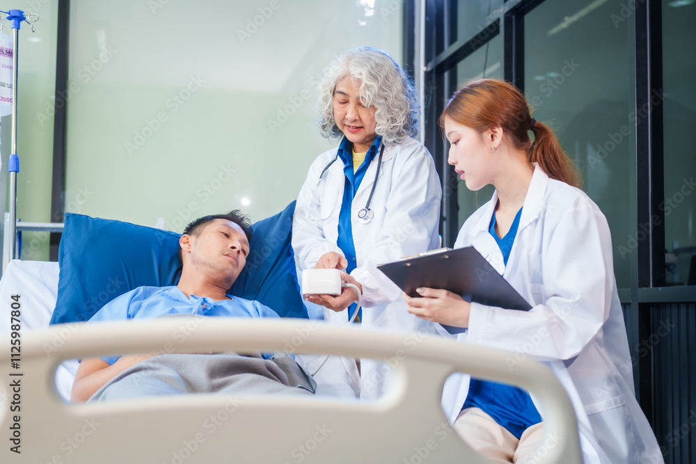 Fototapeta premium Two female doctors examine a patient lying on a hospital bed,discuss the medical chart,administer medicine,and provide encouragement, ensuring compassionate care and fostering the patient's recovery