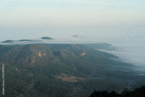 Panorama view layers of mountain with the fluffy white fog between the mountains and clear sky in background