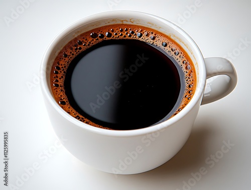 A top-down view of a black coffee in a white cup against a pure white surface. The minimalist approach accentuates the contrast between the inky liquid and its pristine environment. The circular 