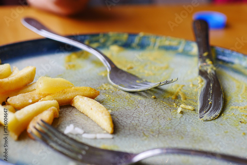 An empty plate with a spoon rests after a delicious, satisfying meal has been enjoyed photo