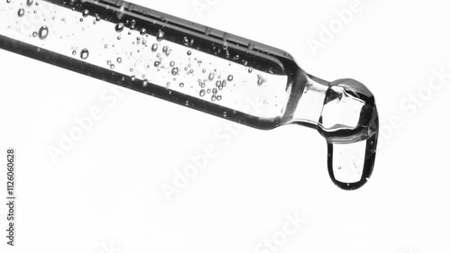 Closeup cosmetic serum fluid gel with bubbles from dropper, pipette over white