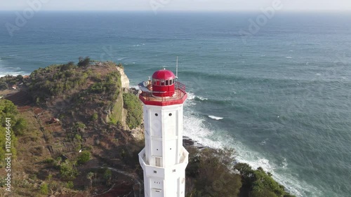 Aerial view of mercusuar or a lighthouse on a hill overlooking a body of water in the Baron Beach. photo