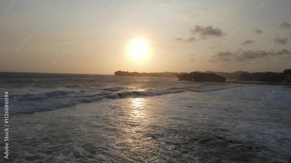 Aerial view of sunset golden hour sandy beach and splashing waves in Baron Beach, Indonesia. Aerial view of sunset golden hour sandy beach and splashing waves in Baron Beach, Indonesia.