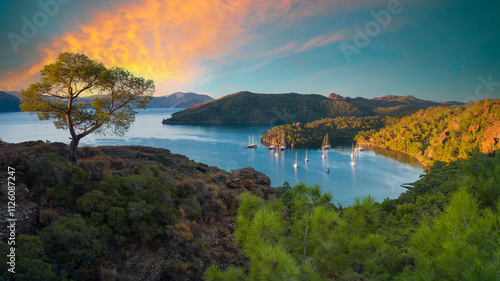 Fototapeta Naklejka Na Ścianę i Meble -  Tranquil bay view at sunrise on the Mediterranean coast of Turkey. View of a natural marina. Panoramic nature view for summer vacation. Marmaris, Turkey