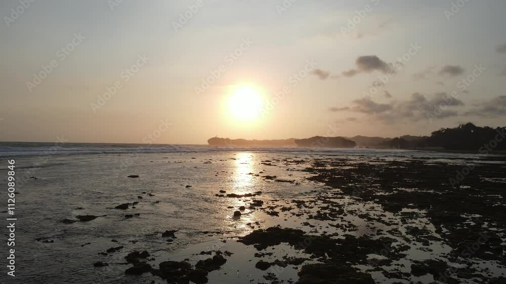 Aerial view of sunset golden hour sandy beach and splashing waves in Baron Beach, Indonesia. Aerial view of sunset golden hour sandy beach and splashing waves in Baron Beach, Indonesia.