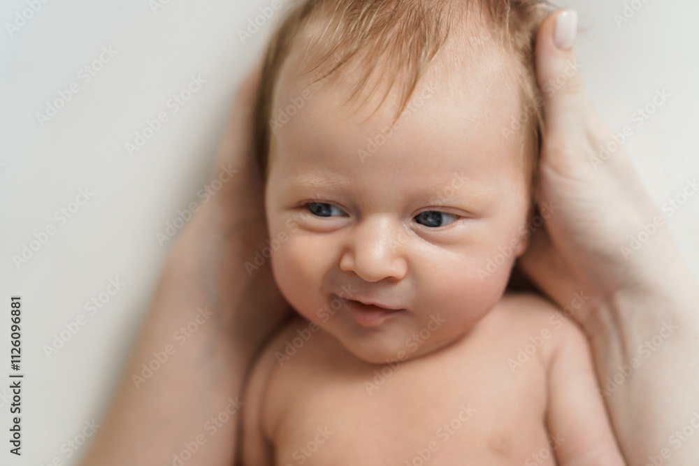 Close-up of newborn baby gently held in adult hands Close-up of newborn baby gently held in adult hands