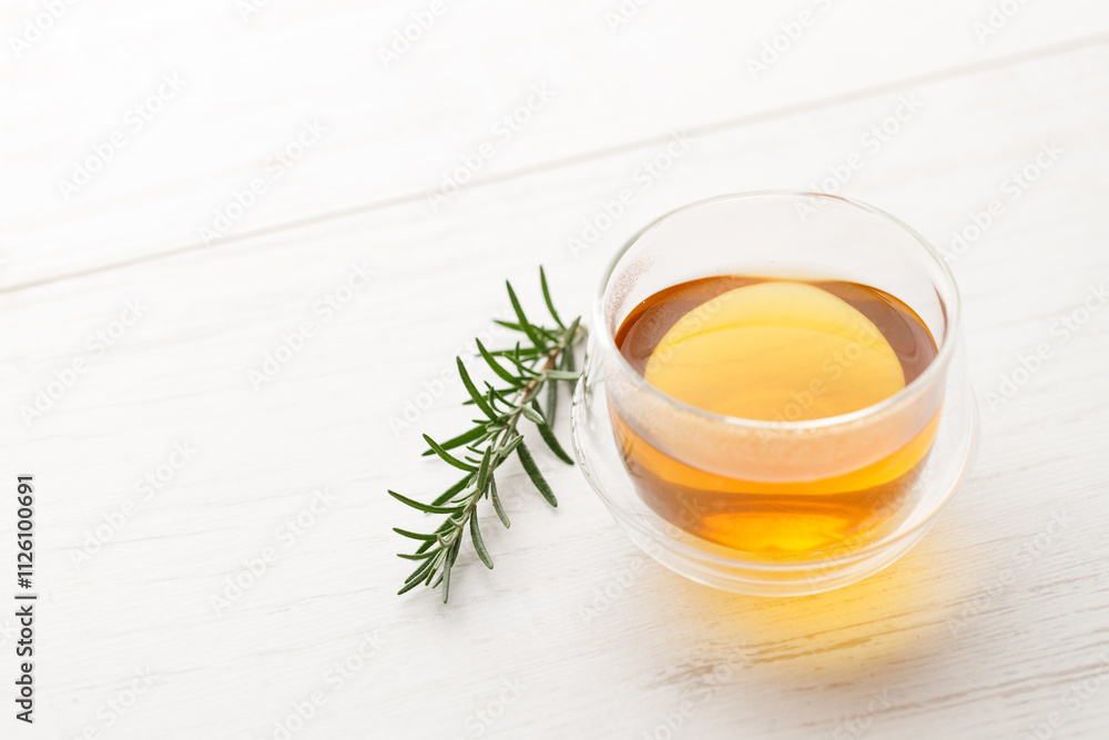 Cup of hot tea blended from rooibos, spearmint, apple, baobab on white wooden table. Cup of hot tea blended from rooibos, spearmint, apple, baobab on white wooden table.