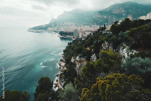 A breathtaking view of Monaco's coastline, featuring lush hills and striking cliffs along the shimmering sea under a moody sky.