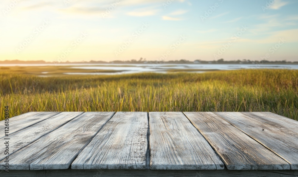 A wooden table in the foreground with a serene landscape of grass and water in the background. A wooden table in the foreground with a serene landscape of grass and water in the background.