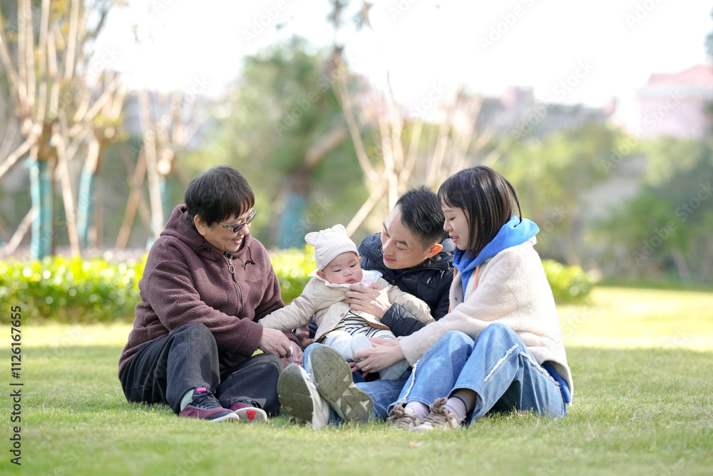 Fototapeta premium 6-month-old little boy plays with Chinese family in private garden in Pudong New Area, Shanghai, China.