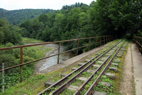 Unused, forgotten narrow-gauge railway tracks and railway bridge in former, abandoned village - Duszatyn in Bieszczady mountain range, Poland photo