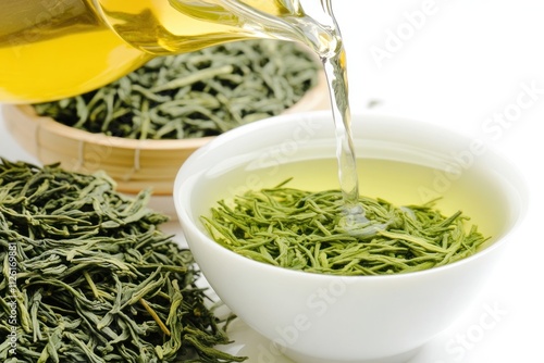 Green tea leaves and brewed tea in a bowl, showcasing tea preparation.