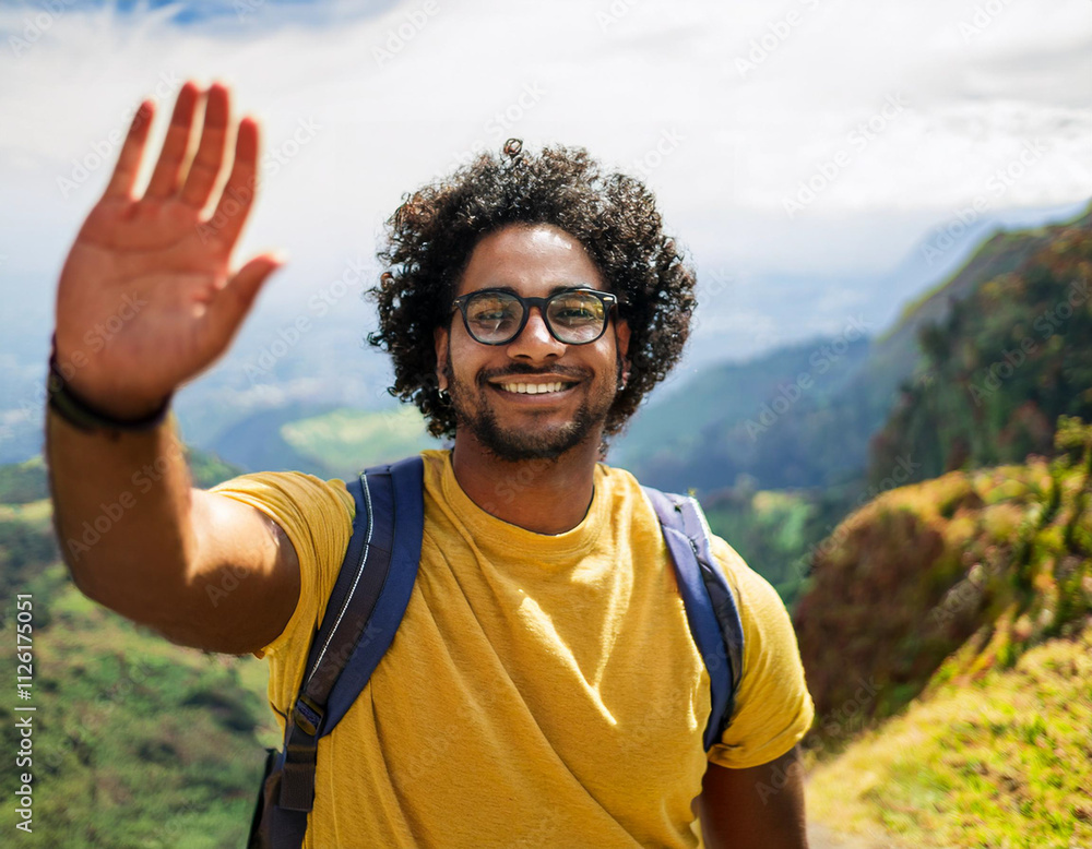 Fototapeta premium Young Man Waving from a Mountain Trail with Scenic Views