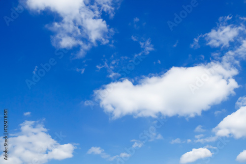 Blue sky with white clouds. The background is a clear blue sky without any clouds. A wide-angle view of the entire picture, showing vast and endless skies. photo