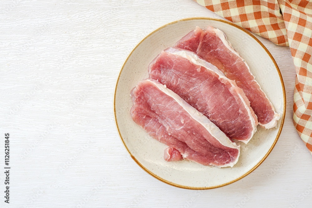Sliced pork in ceramic plate on a white background, top view
Sliced pork in ceramic plate on a white background, top view