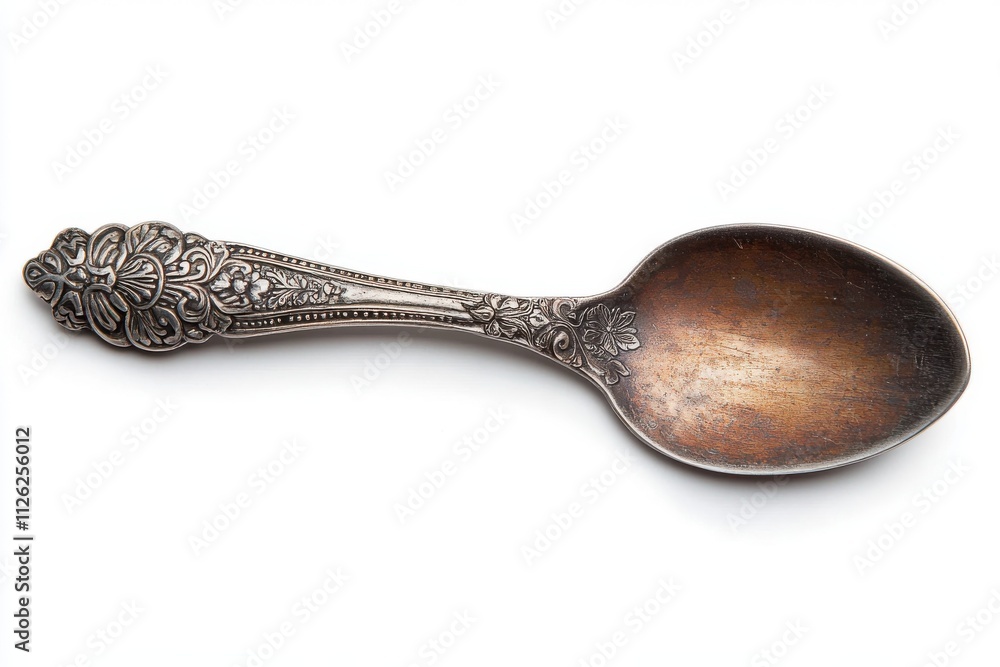 Antique spoon featuring an ornate engraved handle with detailed patterns and a smooth Antique spoon featuring an ornate engraved handle with detailed patterns and a smooth