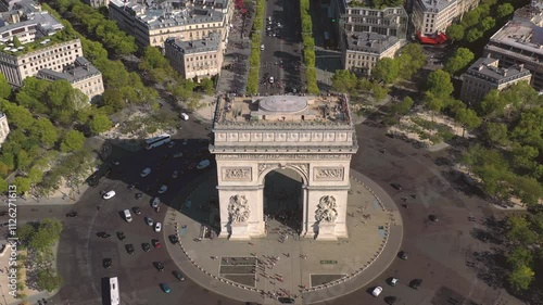 PARIS, FRANCE - OCTOBER 3, 2024: Aerial view of Arc de Triomphe surrounded by bustling streets and trees in vibrant autumn colors photo