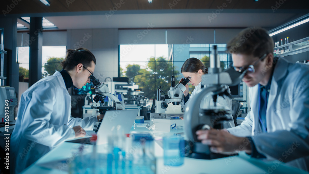 Obraz premium Molecular Biology Research Scientists Looking at DNA Samples Under a Microscope in an Applied Science Laboratory. Young Lab Engineers in White Coat Working with Colleagues