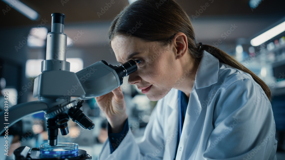 Portrait of a Beautiful Caucasian Student Working on a Research Project in College. Medical Research Scientist Looking at Biological Samples Under a Microscope in an Applied Science Laboratory Portrait of a Beautiful Caucasian Student Working on a Research Project in College. Medical Research Scientist Looking at Biological Samples Under a Microscope in an Applied Science Laboratory