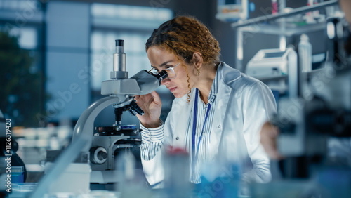 Portrait of a Multiethnic Student Working on a Research Project in College. Medical Research Scientist Looking at Biological Samples Under a Microscope in an Applied Science Laboratory