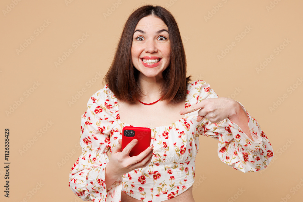 Young surprised shocked woman wear white top casual clothes hold in hand use point index finger on mobile cell phone isolated on plain pastel light beige background studio portrait. Lifestyle concept.