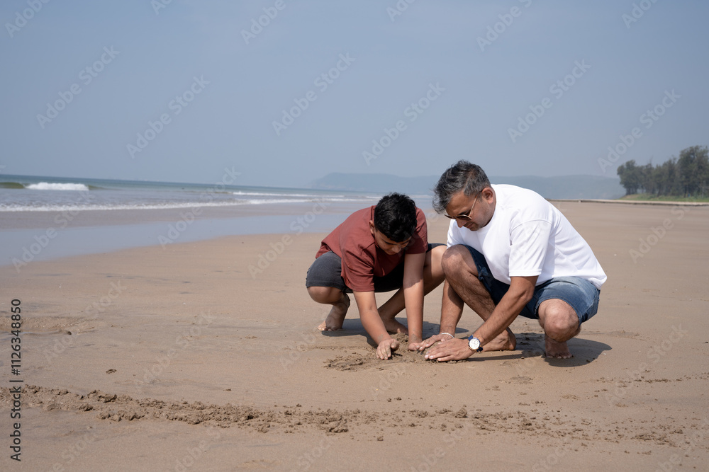 Happy Father and teen Son Having Fun Playing sand on the Beach at Sunset Happy Father and teen Son Having Fun Playing sand on the Beach at Sunset