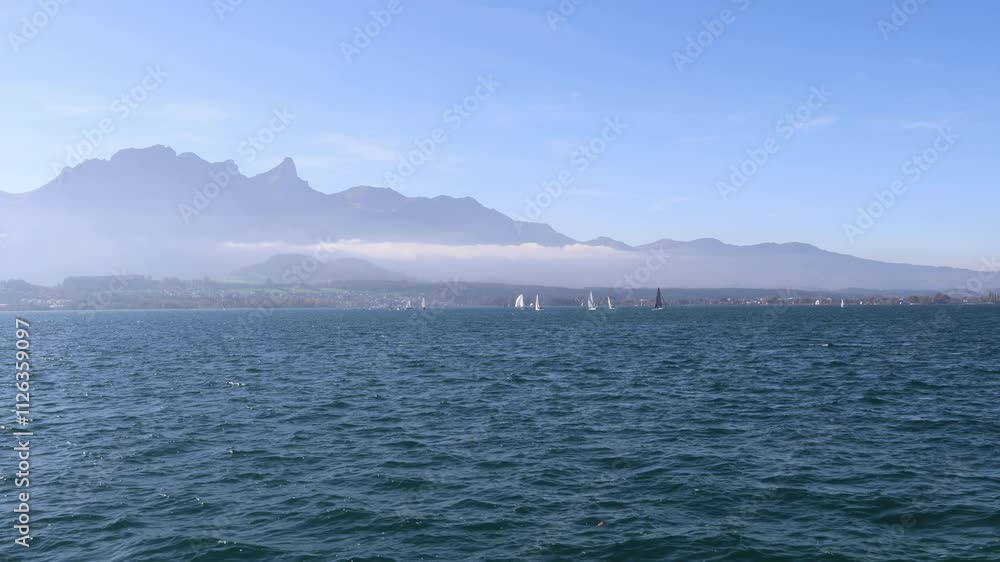 Sailboats sailing on the lake with mountains in the background, Thun lake Switzerland Sailboats sailing on the lake with mountains in the background, Thun lake Switzerland