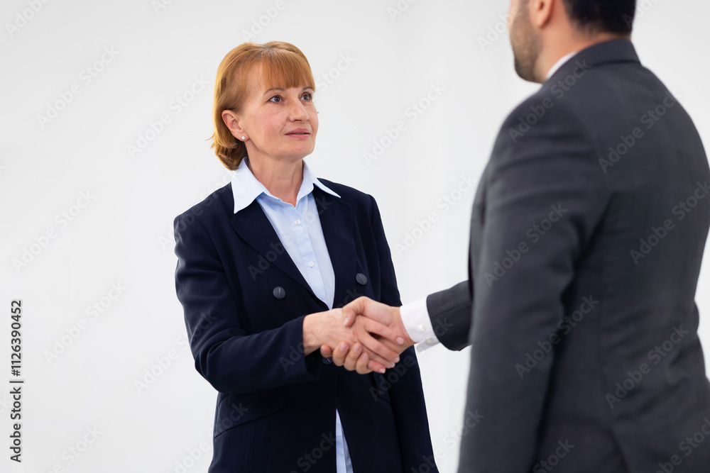 Successful hand shaking after good deal. Caucasian senior business female People shaking hands on business cooperation agreement. Happy mature old female planning with company team in meeting Successful hand shaking after good deal. Caucasian senior business female People shaking hands on business cooperation agreement. Happy mature old female planning with company team in meeting