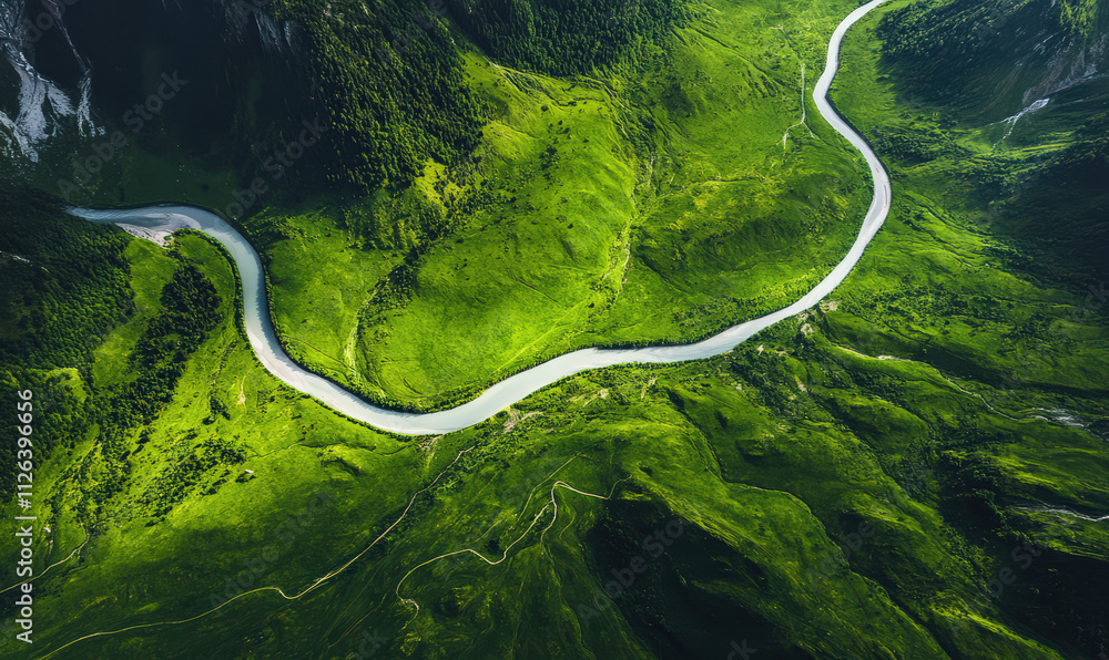 Serene aerial view of winding road through lush green valley peaceful landscape tranquil scene