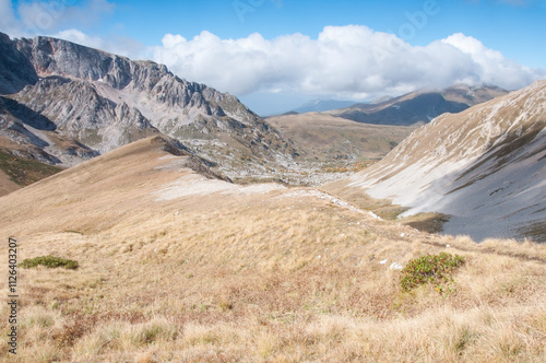 Grass-covered slopes of Caucasus mountains in autumn with a part of the Mount Pshekhu-Su in the background, Russian Federation