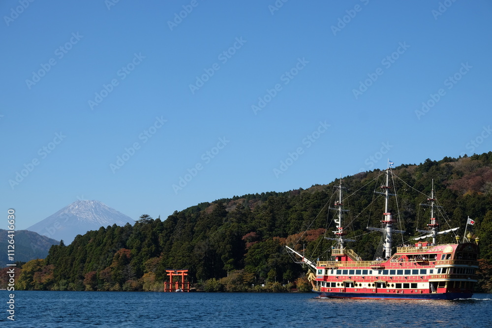 Fototapeta premium A sailboat glides through the tranquil waters of the Mediterranean, its sails catching the gentle summer breeze