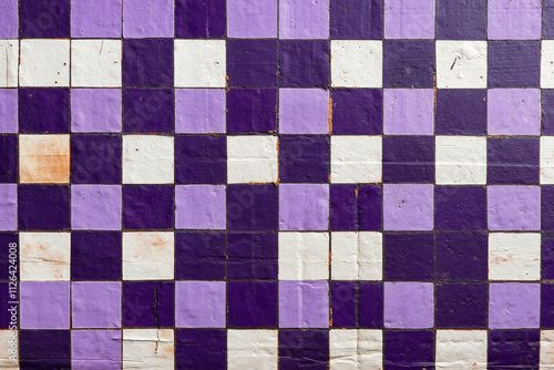 A purple and white checkered wall with peeling paint on it