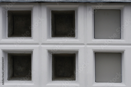 Cremation niches on wall in columbarium designed for storing cinerary urns in funeral property. Cremation niches for urns closeup. photo