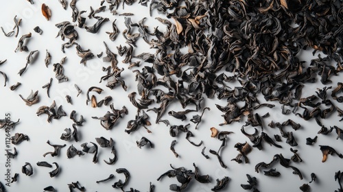 Dried tea leaves scattered on a light background showcasing intricate textures and natural hues for culinary and wellness themes photo