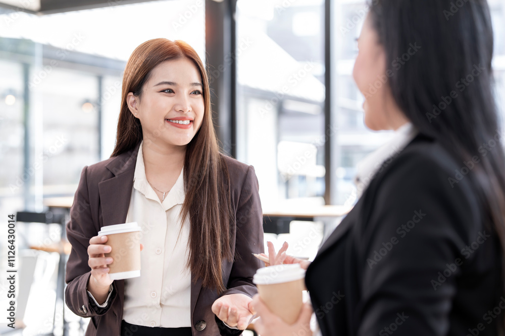 Obraz premium Friendly female colleagues having good relationships, talking together at workplace during coffee break,