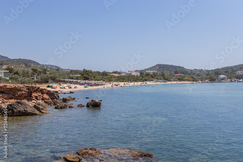 A lively beach in Thassos, Greece, featuring golden sands, clear waters, and scenic surroundings. photo