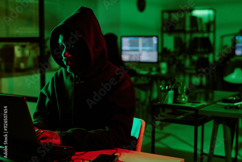 Medium close up photo f web criminal in room illumed with green non lights photo