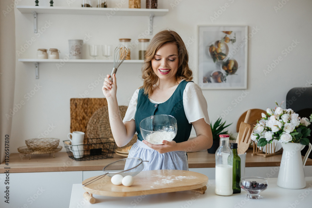 Beautiful girl housewife cooks in the kitchen Beautiful girl housewife cooks in the kitchen
